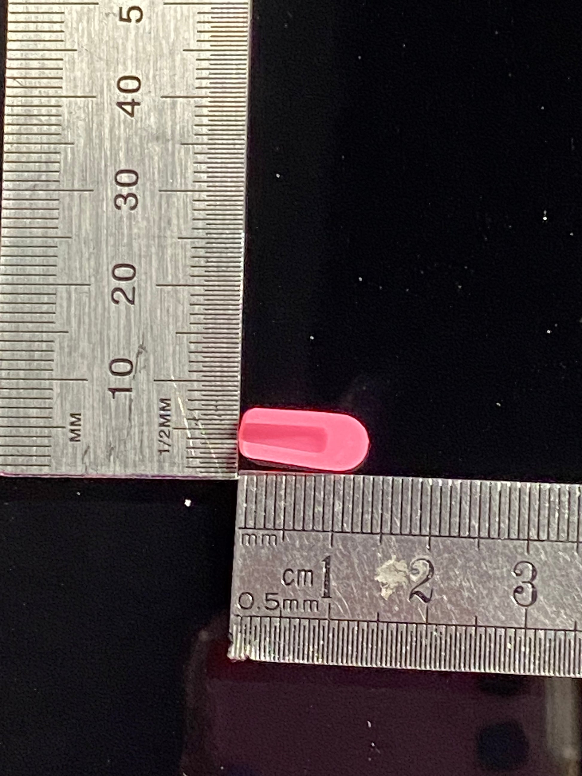 pink silicone end cap, inverse view. measuring base and length against a ruler