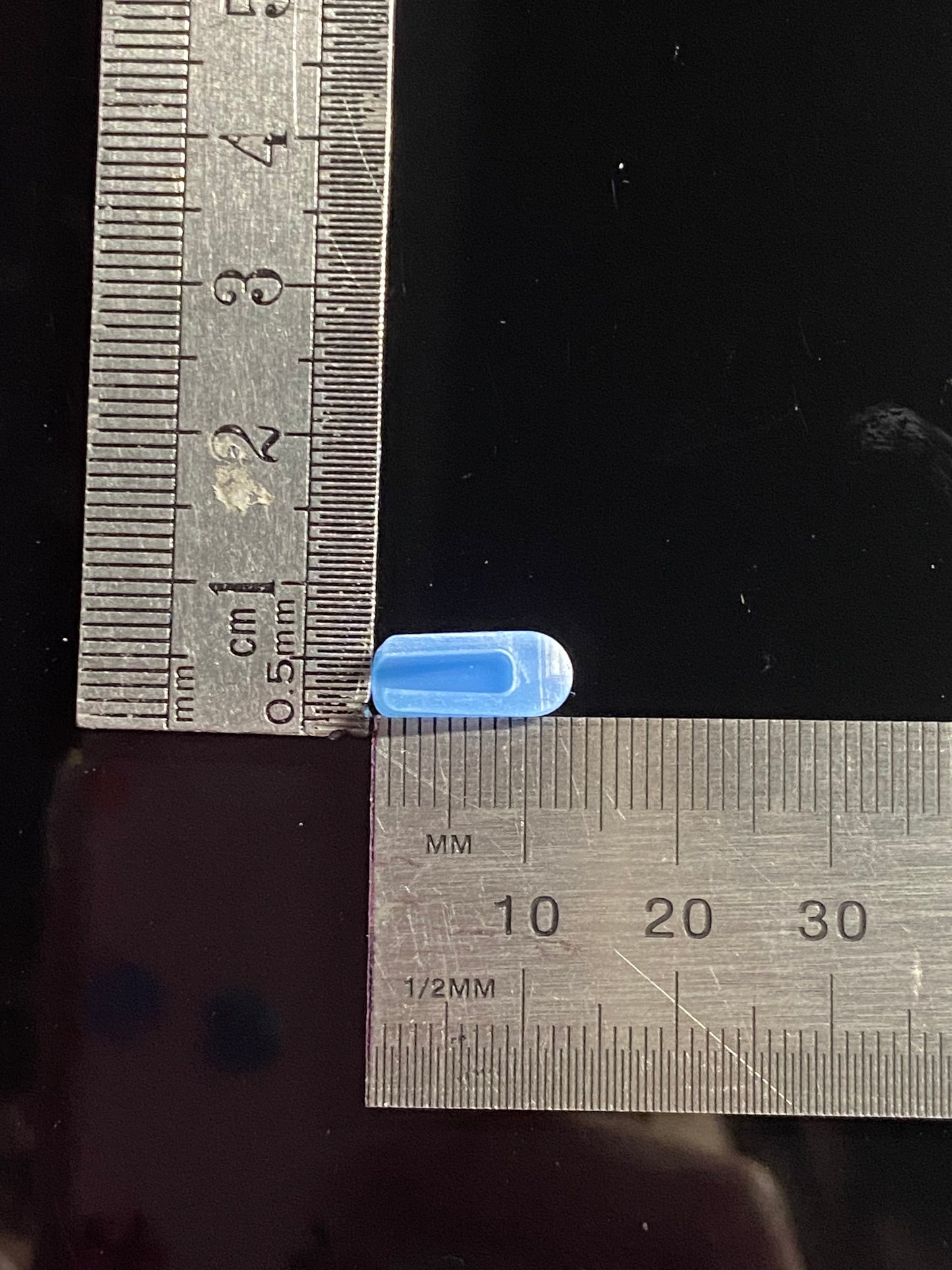 Dark blue end cap, inside view against ruler measuring approximately 12mm in length and 4mm at base. 
