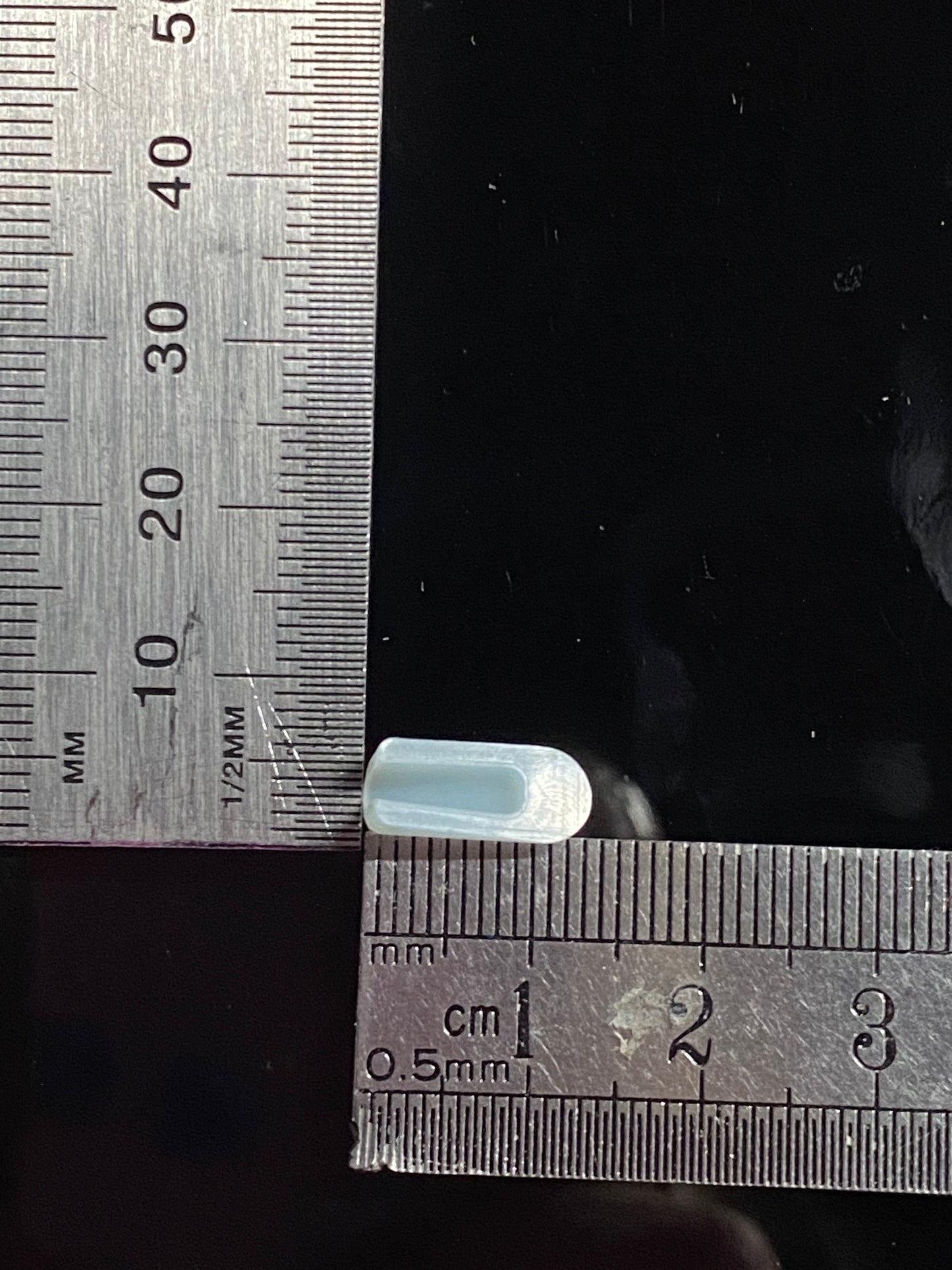 ice bleu end cap, inverse view against rulers, measuring base and length