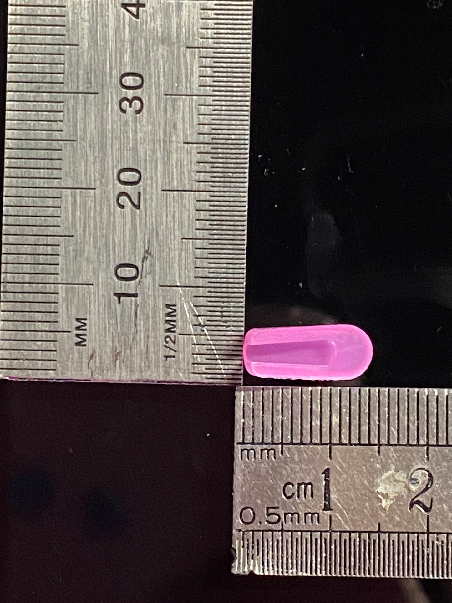 purple end cap, inverse view set against rulers measuring base and length