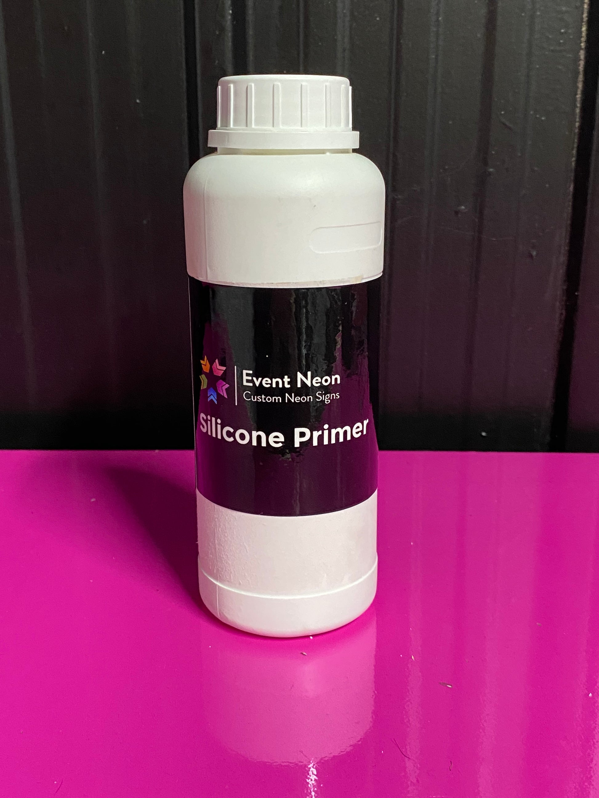Silicone Primer bottle on a black and purple background