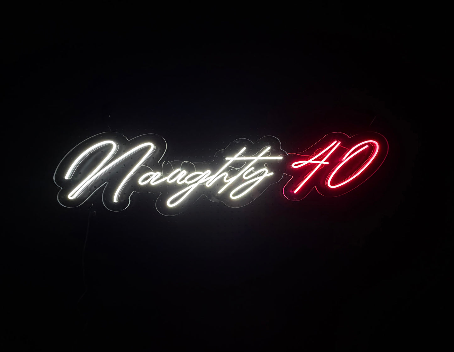 White and Pink LED Neon "Naughty 40" cursive on clear acrylic