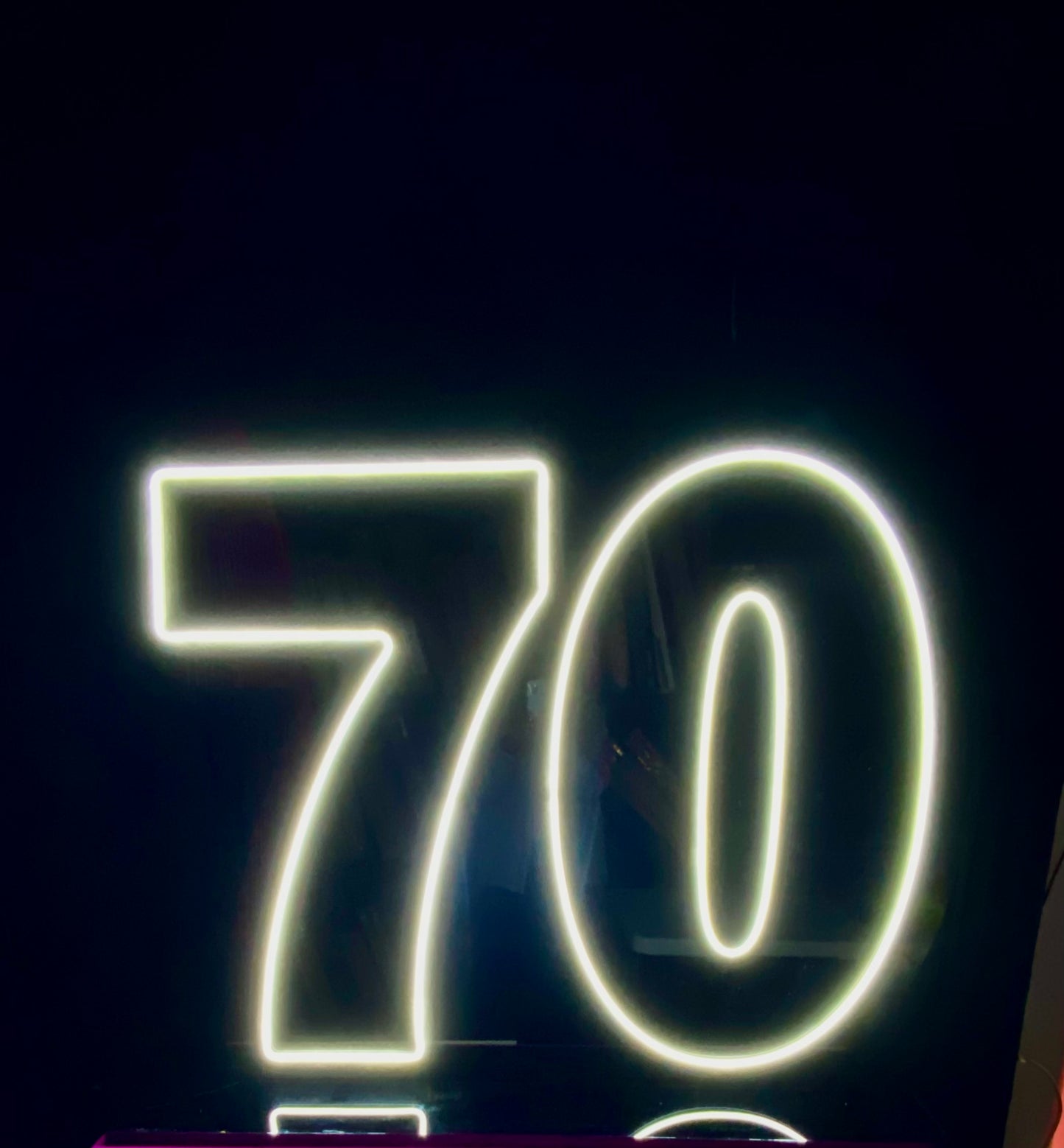 White LED Neon "70" on black acrylic with black stand