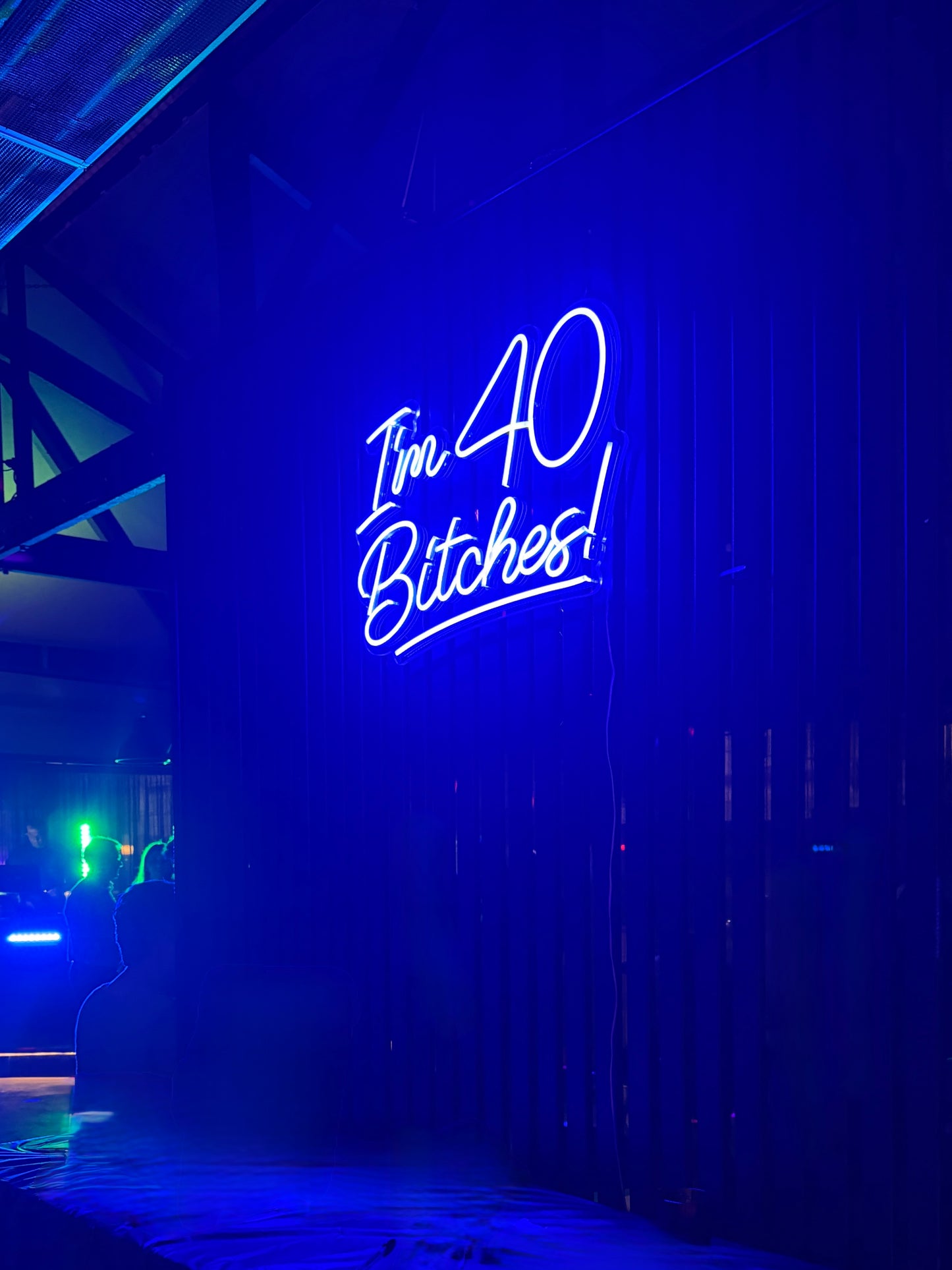 Neon sign  "I'm 40 Bitches!" with text on a dark background