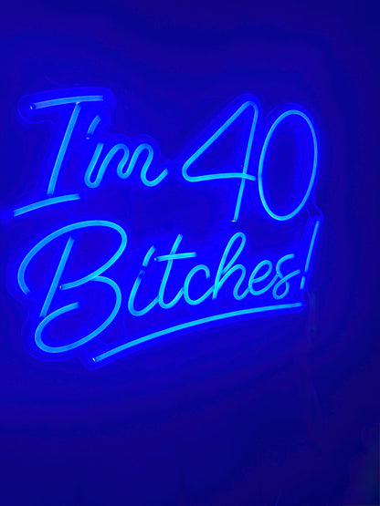 Neon sign with blue text 'I'm 40 Bitches!' 