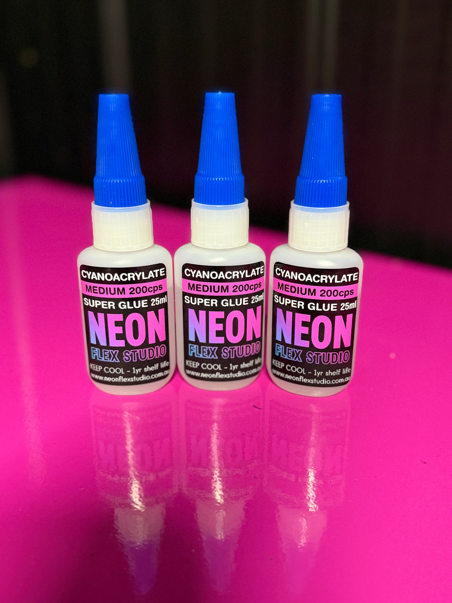 Three bottles of Neon Flex Studio super glue medium viscosity