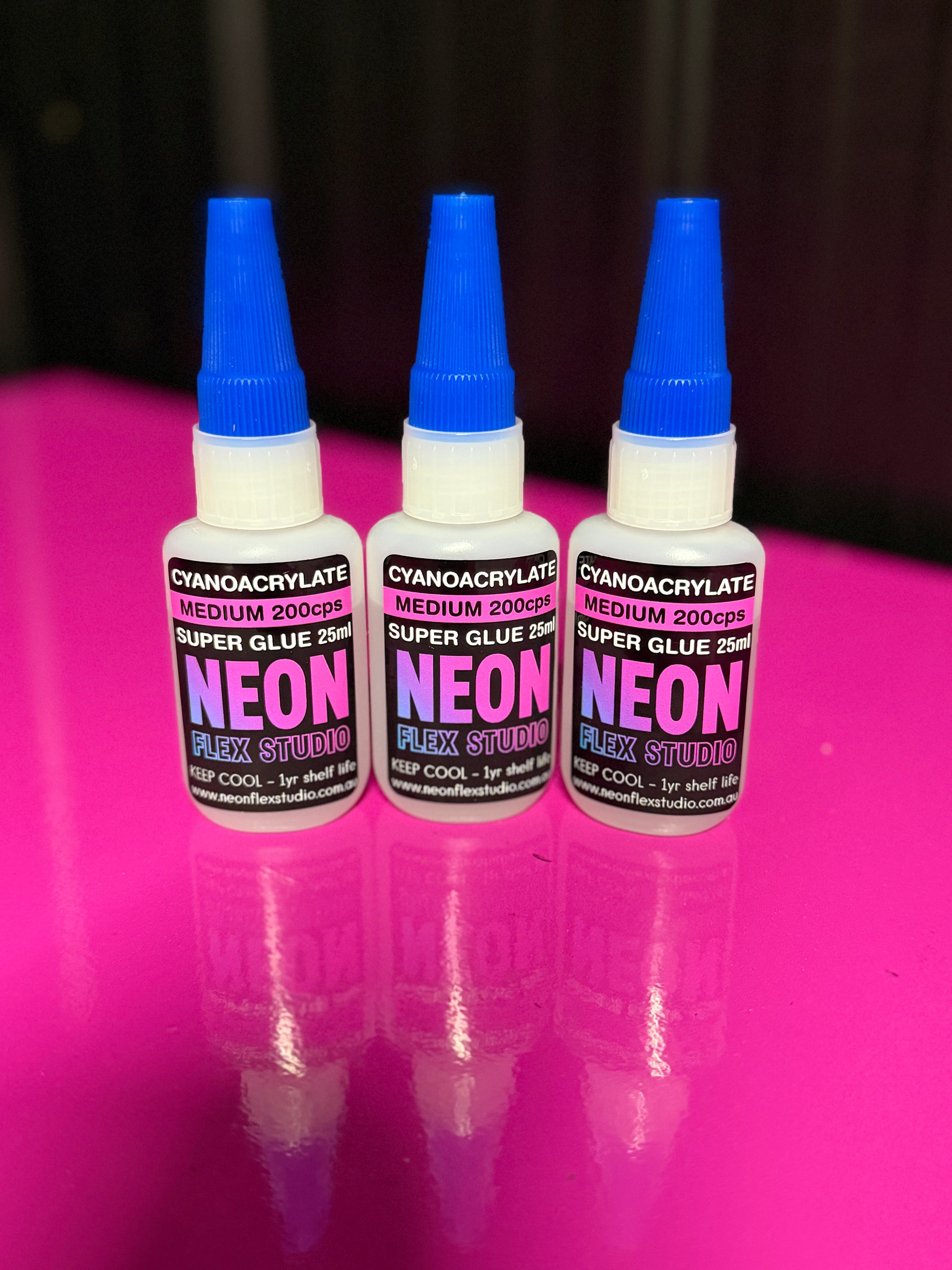 Three bottles of Neon Flex Studio super glue medium viscosity
