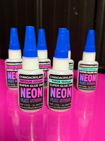 Neon Flex Studio glue bottles on a pink and black background