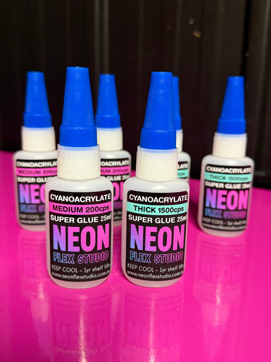Neon Flex Studio glue bottles on a pink and black background
